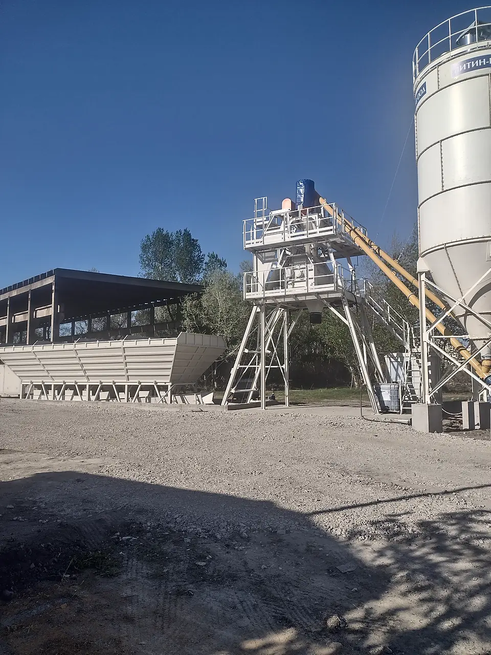 Mixer tower and screw conveyor of a concrete batching plant