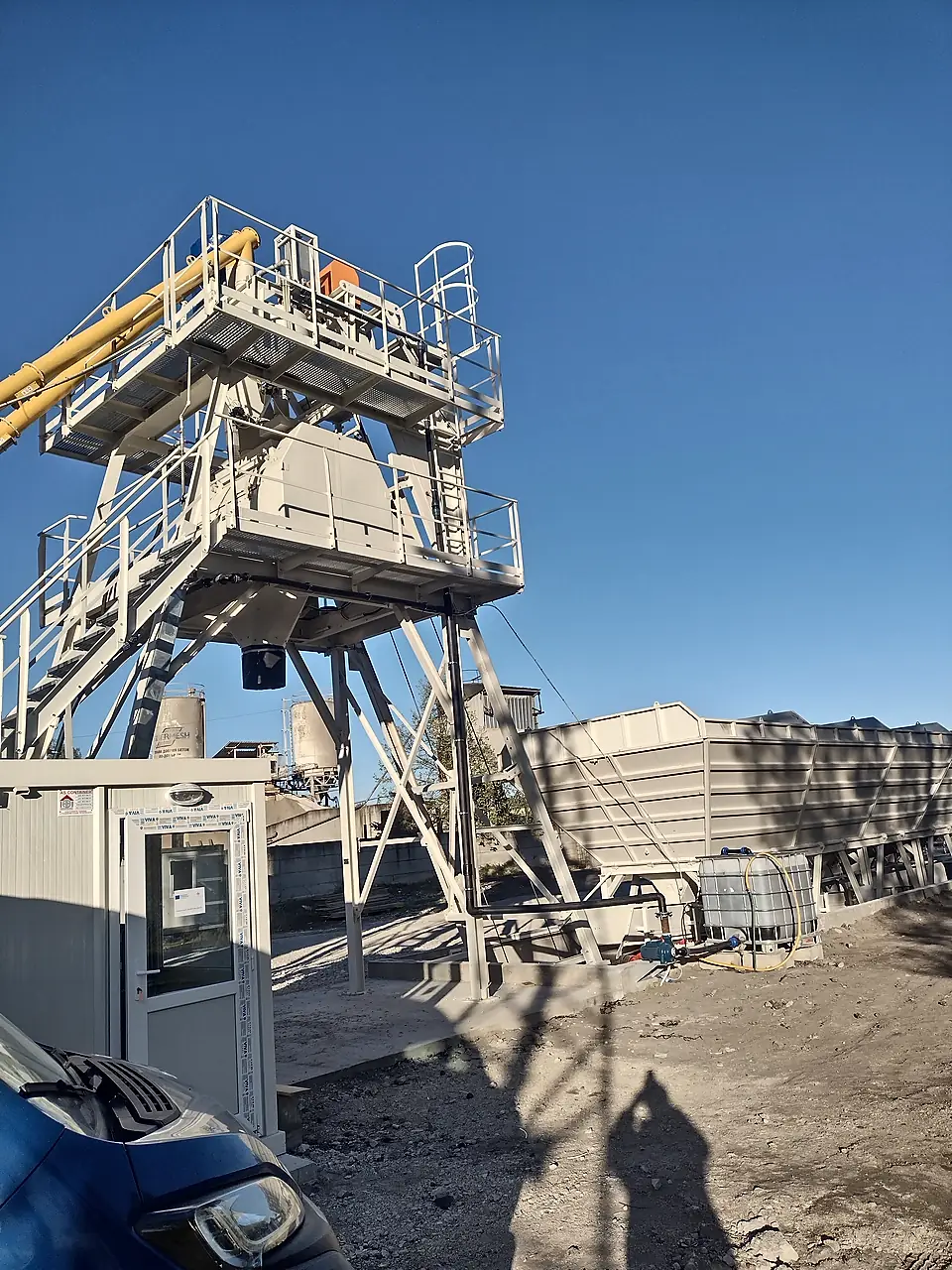 Concrete batching plant with operator container and aggregate bins