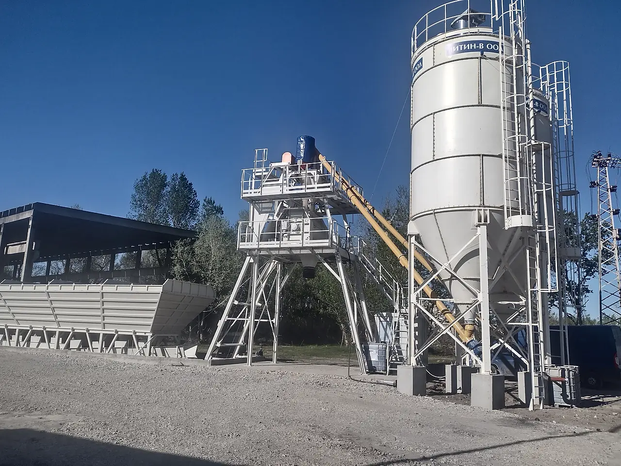 Completed concrete batching plant with cement silo, mixer tower and aggregate bins