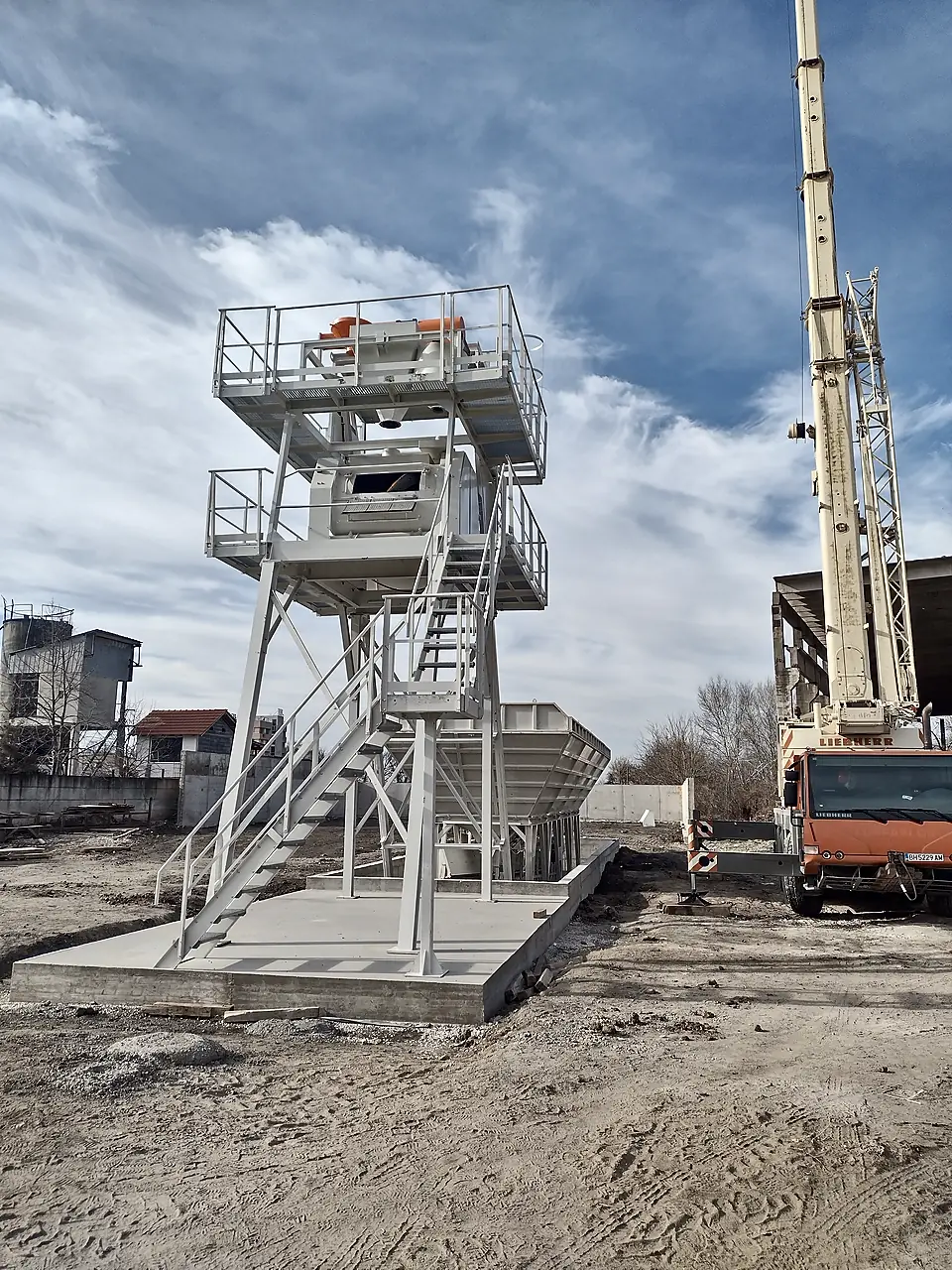 Mobile crane on site during assembly of a batching plant mixer tower