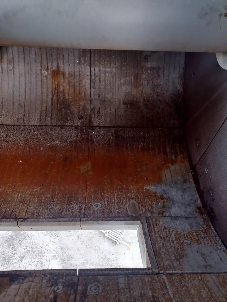 Mixer trough lined with wear plates, with the discharge door