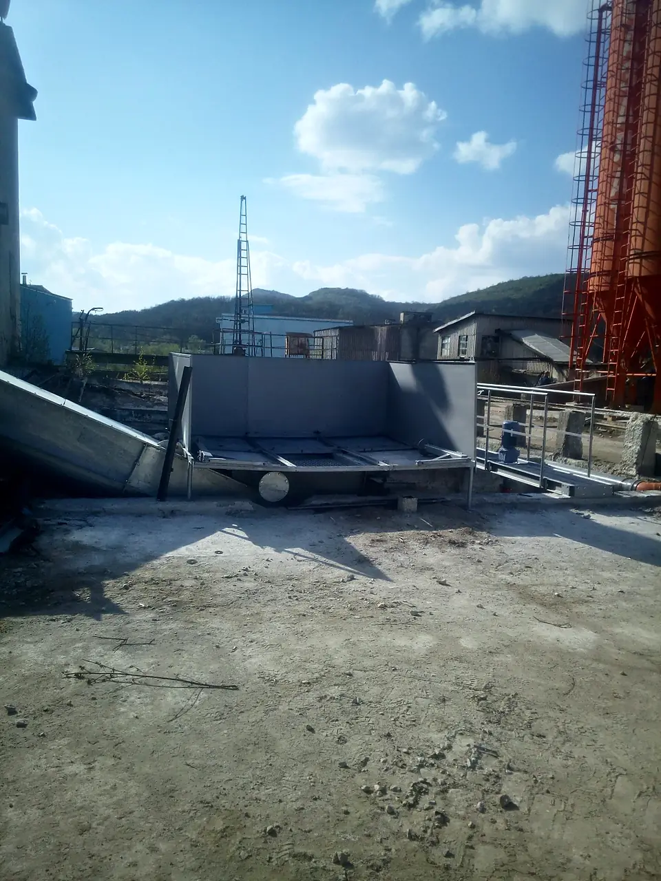 Concrete recycler basin and screw conveyor on site