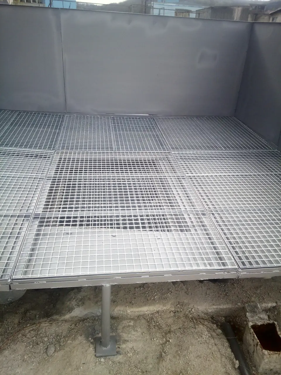 Steel grating over a concrete recycler washout pit