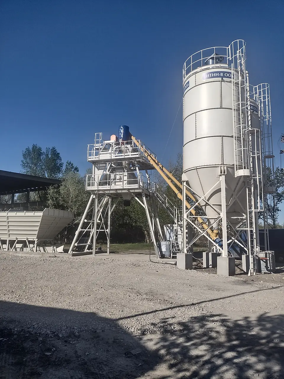 Full view of a stationary concrete batching plant with cement silo